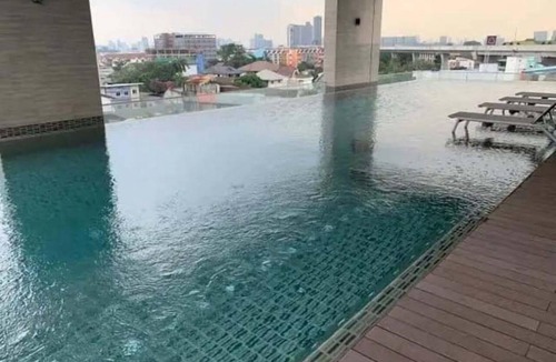 Nonthaburi Apartment | Modern 1-bedroom condo for up to 2 guests at Amber by Ester Star. Includes a separate bedroom, living area, kitchen, dining space, washing machine, balcony, city view and access to pool, gym, co-working space and shared building amenities.
