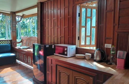 Thong Chai House | Traditional Thai wooden house on stilts set in a coconut orchard near the beach
